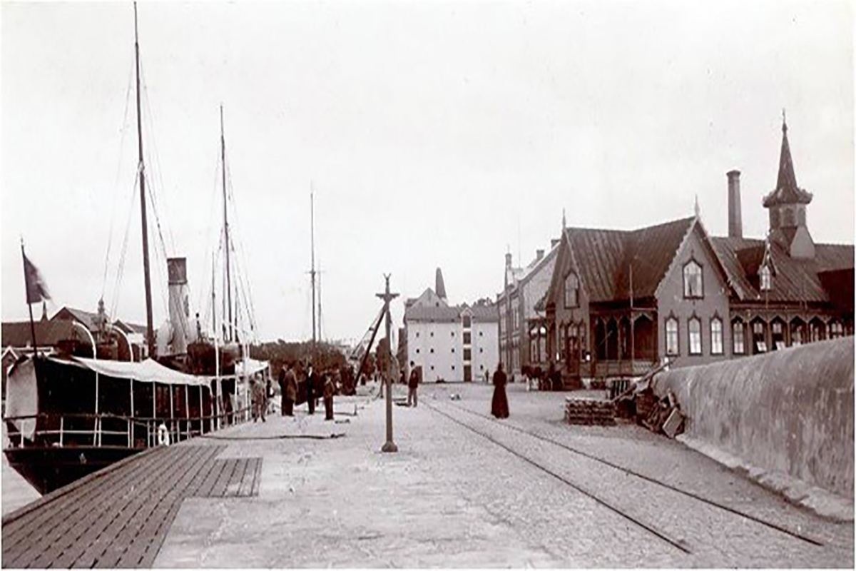 Gamla varmbadhuset i hamnen, en träbyggnad med torn som ligger mitt emot kallbadhuset. Historisk bild.
