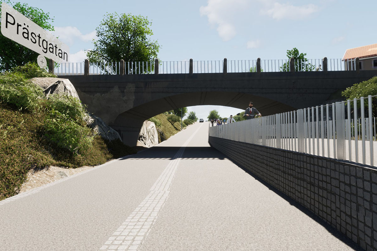 Vy från söder till norr. Tvåfilig väg som går under en bro. Till höger en gång-och cykelväg som är uppbyggd så att cyklisterna cyklar på en högre nivå än körbanan.