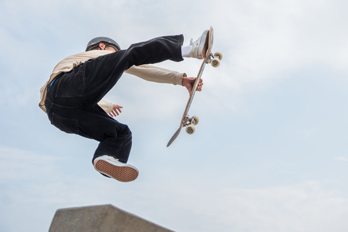 Ung skateboardåkare gör ett trick i luften