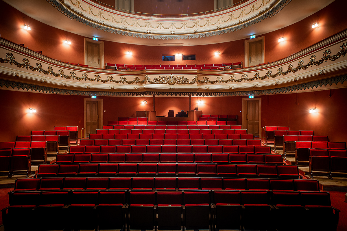 Teaterns sedd från scenen med alla stolar i rött.