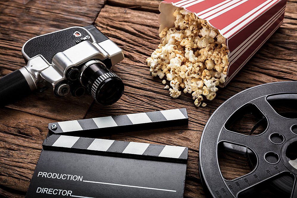Filmkamera och popcorn liggandes på ett underlag av trä.