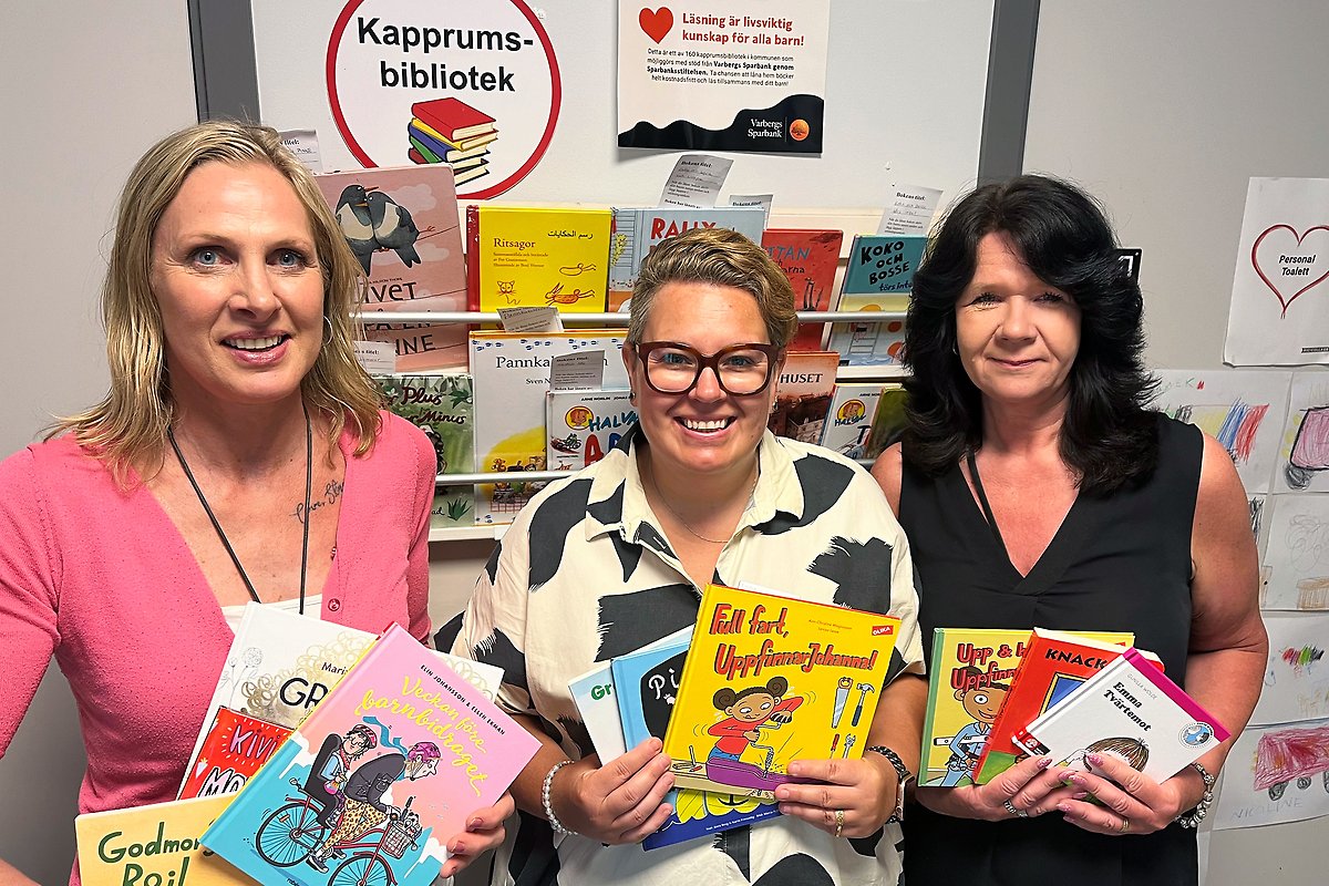 Maria Karleyel, Emma Torstensson och Catrine Yngbro visar upp några av de böcker som går att låna på Kapprumsbiblioteket.